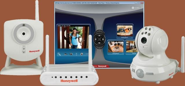 A Honeywell wireless security system displaying a software interface showing camera feeds, accompanied by three different Honeywell cameras and a wireless router, ensures robust alarm monitoring over your broadband Internet connection.