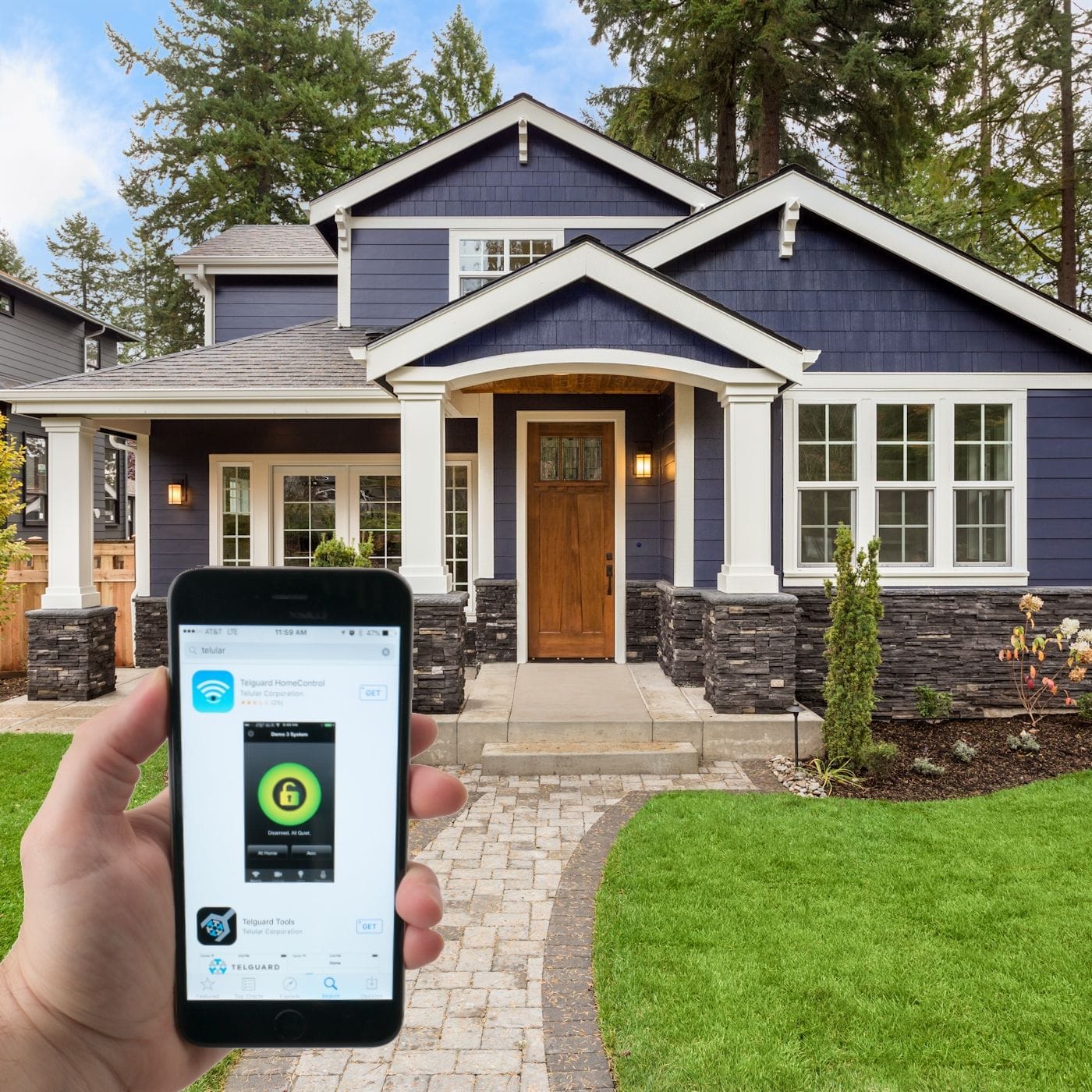 A person is holding a smartphone displaying a smart home app. In the background, there is a modern two-story house with a blue exterior, white trim, wooden front door, and a well-maintained lawn showcasing their new national home security system.